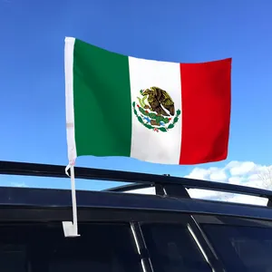 Mexican car window flag with white pole mounted on a vehicle window against blue sky