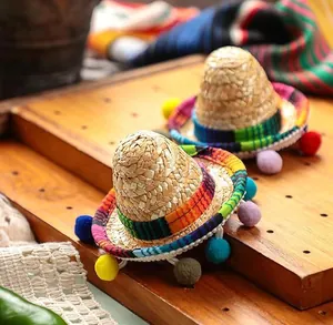 Close-up detail of mini Mexican straw hat with colorful pom-poms and rainbow trim