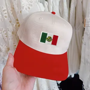 Detailed view of a Mexican flag embroidered patch on a cream and red baseball cap.