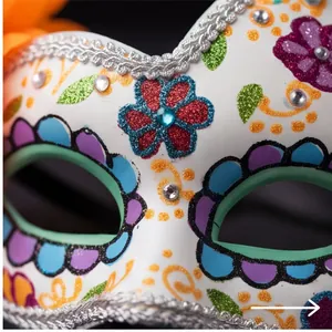 Macro view of a white Day of the Dead mask featuring glitter flowers and rhinestones