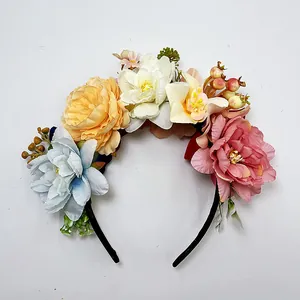 Detailansicht verschiedener bunter Kunstblumen auf einem Blumenstirnband im Boho-Stil
