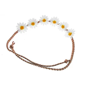 Primo piano di una fascia hippie intrecciata con sei margherite bianche per feste