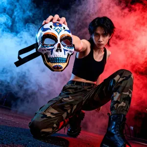 Asian male model posing with colorful Day of the Dead resin skull mask in smoky studio