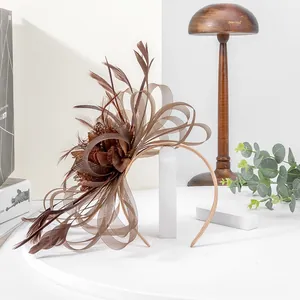 Detailed view of an elegant brown mesh fascinator headband with feather accents.