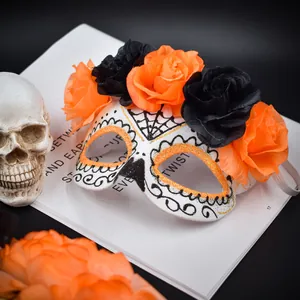 Détail du masque Jour des Morts avec roses en tissu orange et noires