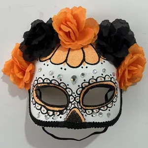 Close-up of a Day of the Dead mask with vibrant orange and black floral decorations
