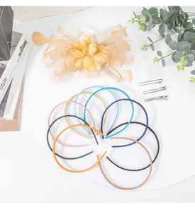 Detailed shot of champagne mesh feather hair accessory and set of thin colorful headbands