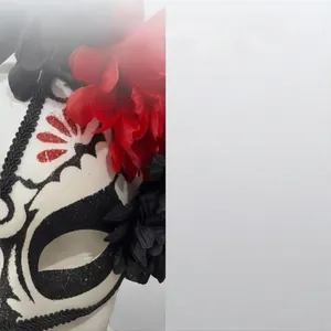 Détail d'un masque du Jour des Morts avec des fleurs en soie rouges et des motifs pailletés