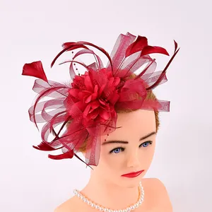 Close-up detail of an elegant red mesh and feather fascinator headpiece for wedding party