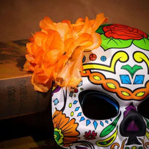 Gros plan du masque de crâne du Jour des Morts avec décoration florale orange vif.