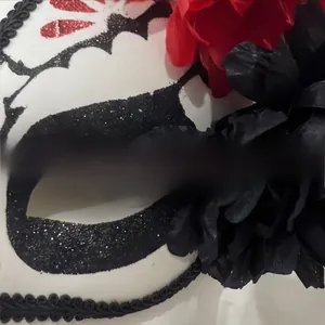 Détail rapproché d'un masque mexicain du Jour des Morts avec paillettes et fleurs rouges