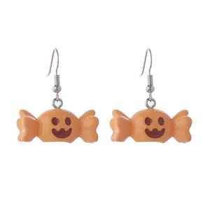Vue détaillée des boucles d'oreilles bonbon orange pour Halloween avec un joli sourire.