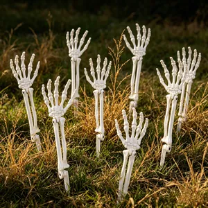 Realistische weiße Skeletthände als Gartenstecker im Rasen für Halloween-Dekoration