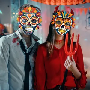 Modelle tragen farbenfrohe mexikanische Totenkopfmasken aus Papier auf einer Party.