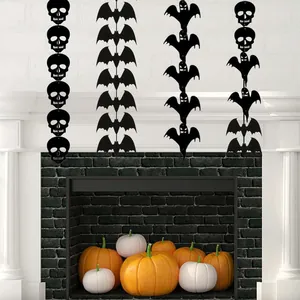 Ghirlanda di Halloween in feltro nero appesa sopra un camino decorato con zucche.