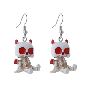 Vue détaillée de boucles d'oreilles squelette blanches à yeux rouges pour bijoux Halloween