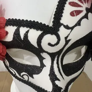 Ornate Mexican Day of the Dead masquerade mask with black glitter patterns and red flower