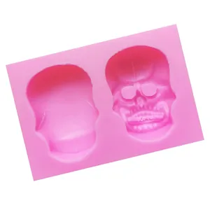 Close-up of pink silicone mold with two Halloween skull mask patterns for baking.
