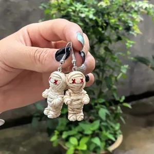 Détail de boucles d'oreilles momies d'Halloween mignonnes avec yeux en X rouges