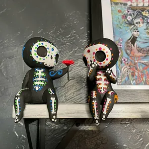 Handbemalte Zucker-Totenkopf-Figuren aus Harz, Paar auf Regal mit roter Blumendetail