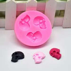 Detailed view of pink silicone skull mold with black and pink fondant skull samples