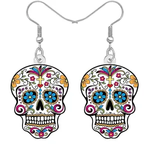 Gros plan de boucles d'oreilles colorées en forme de crâne de sucre avec motifs floraux.