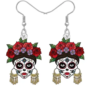 Détail de boucles d'oreilles tête de mort en acrylique avec motifs floraux colorés