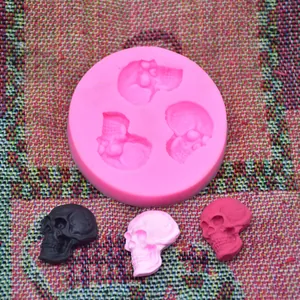 Close-up view of a pink silicone mold for skull-shaped cake fondant and plaster decorations