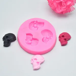 Detail view of pink 3-cavity skull silicone mold with finished skull casts