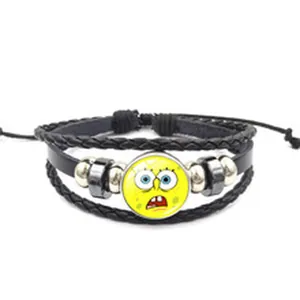 Détail d'un bracelet en cuir tressé arborant un cabochon en verre de dessin animé