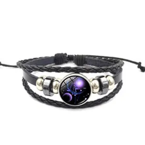 Détail du bracelet multicouche en cuir tressé noir avec gemme en verre céleste