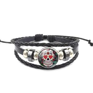 Détail du bracelet en cuir tressé multicouche avec cabochon en verre tête de mort mexicaine.