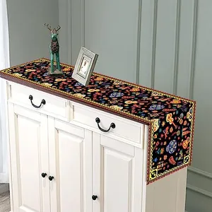 Chemin de table Jour des Morts avec motifs de têtes de mort colorées sur un meuble blanc