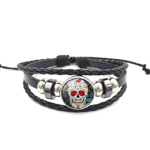 Détail d'un bracelet en cuir tressé multicouche avec un crâne en sucre mexicain coloré