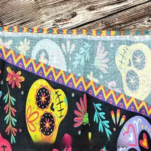 Makrodetail eines Tag der Toten Tischläufers mit Zuckerschädel-Stofftextur