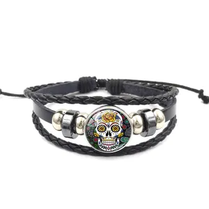 Détail d'un bracelet en cuir tressé multicouche avec breloque Sugar Skull colorée