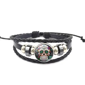 Vue détaillée d'un bracelet en cuir tressé multicouche avec un crâne en sucre coloré.