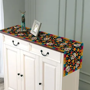Decorative Mexican sugar skull table runner displayed on a classic white cabinet detail