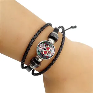 Vue détaillée d'un bracelet en cuir multicouche avec un cabochon crâne en sucre coloré.