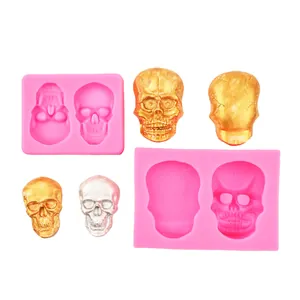 Close-up of pink silicone skull molds and metallic gold and silver finished skulls