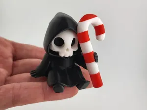 Detalle macro de una linda miniatura de parca impresa en 3D con un bastón de caramelo