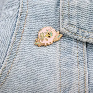 Detailaufnahme einer pastellrosa Zuckerschädel-Emaille-Nadel auf einer Jeansjacke