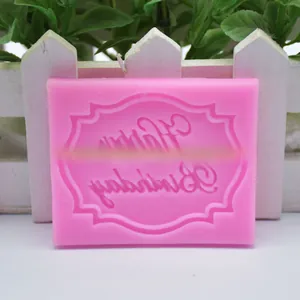 Detailopname van roze siliconen fondantvorm met Happy Birthday tekst voor taart
