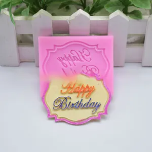 Detailopname van roze siliconen mal en afgewerkte Happy Birthday fondant plaquette