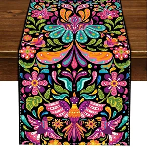 Close-up detail showing vibrant Bohemian Mexican floral pattern on a linen table runner