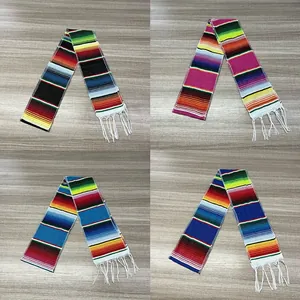 Four distinct color variations of traditional Mexican woven table runners with fringe