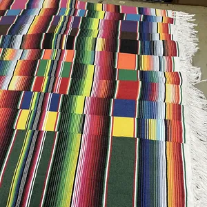 Close-up detail of traditional Mexican striped table runners with white fringe borders