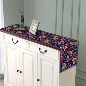 Mexican Day of the Dead table runner with colorful floral sugar skull prints on a cabinet