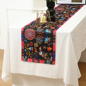 Detailed view of vibrant Mexican floral print table runner on a white party table