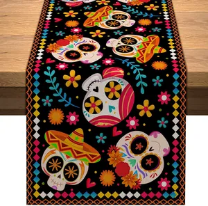 Detailed view of Mexican sugar skull and floral patterns on black linen table runner